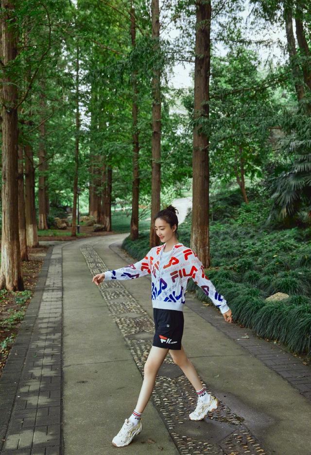 35岁王丽坤晒美照，扎丸子头“素颜肌”减龄，林间起舞长腿更迷人