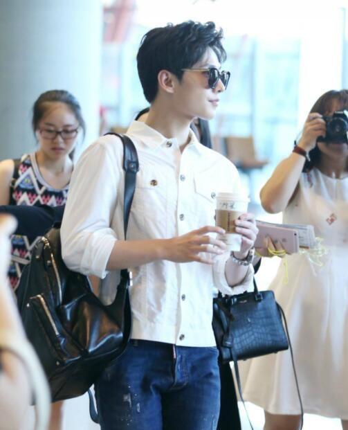 杨洋现身机场粉丝一路跟拍，白衬衫搭墨镜酷帅