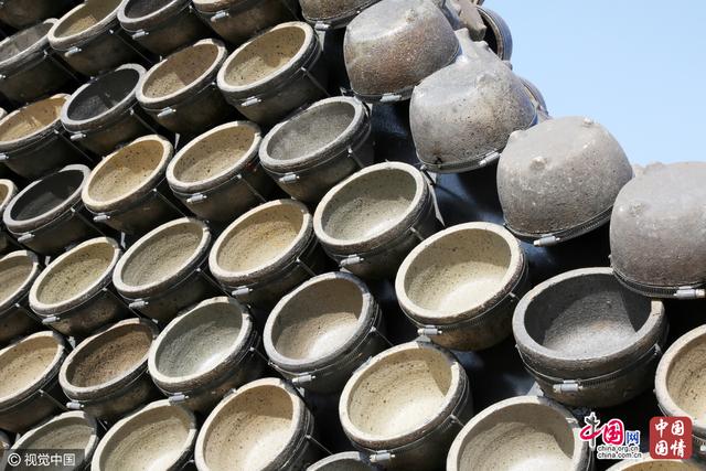 郑州街头现巨型“铜钱”引围观 用2500多个砂锅组成