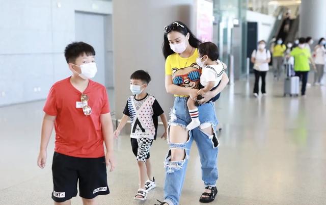 冉莹颖现身机场，戴墨镜配破洞裤穿搭时尚，一人带三娃妈妈力max