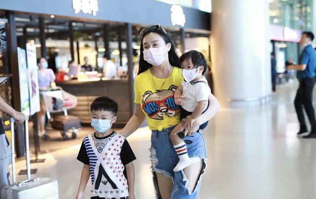 冉莹颖现身机场，戴墨镜配破洞裤穿搭时尚，一人带三娃妈妈力max