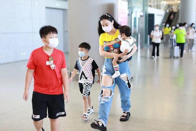 冉莹颖带仨娃走机场！修身T恤勒出“妈妈背”，破洞裤烂到露裤兜