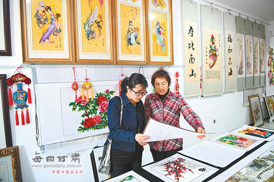 游客在庆阳市西峰区群英香包刺绣有限公司展厅参观