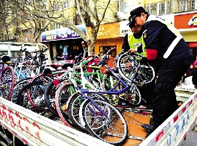执法人员拉走占道经营的电动车自行车 装满4辆车
