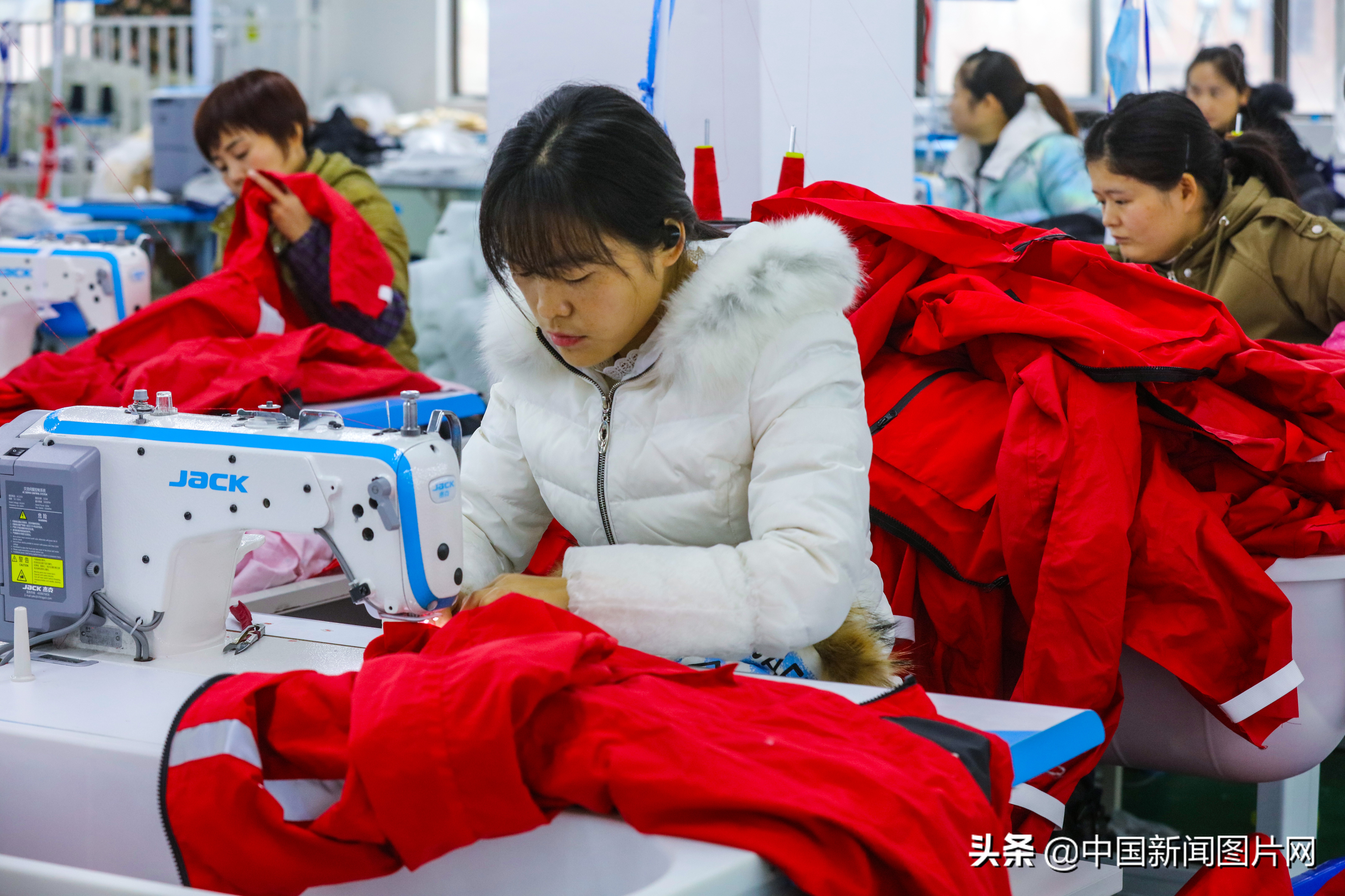 市光山县产业集聚区的良友服饰扶贫车间里工人正在赶做客户订单羽绒服