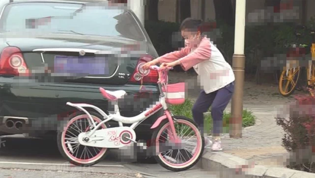 7岁甜馨相当独立，街头骑单车又美又飒，使劲抬