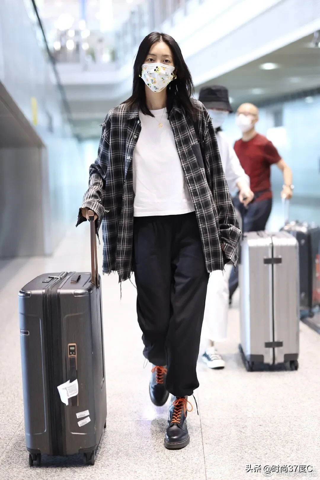 大表姐刘雯身穿黑色格纹衬衫搭配黑色运动裤现身机场，率性自然