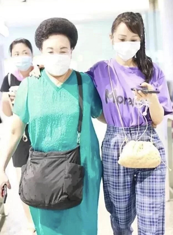 伊能静陪婆婆走机场，扎斜马尾配粉包真显嫩，比一旁秦昊看着还小