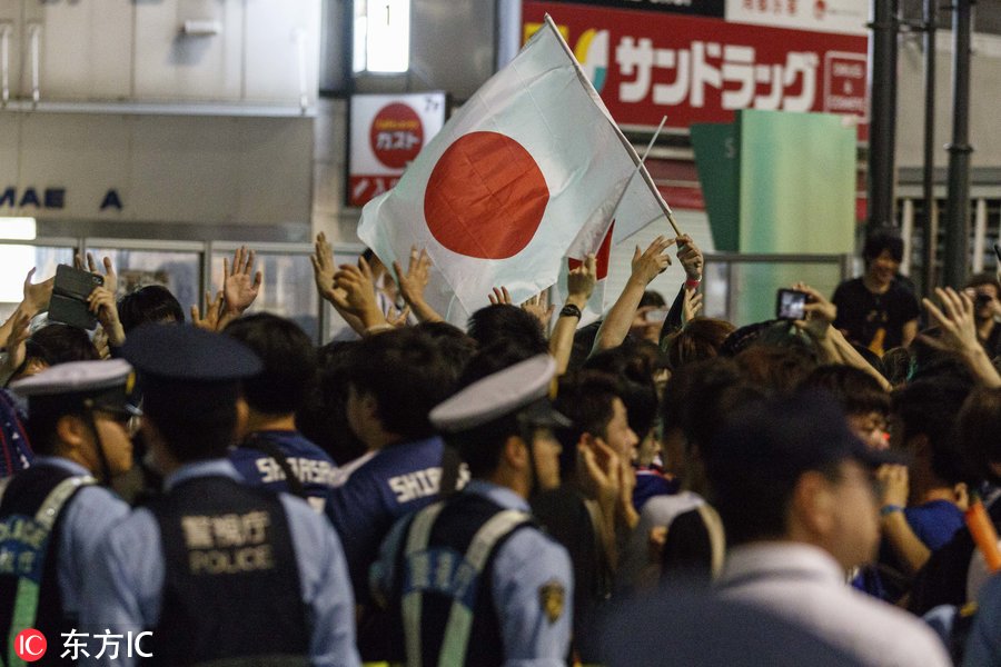 日本世界杯球迷(日本球迷街头狂欢庆祝第三次世界杯小组出线 大量警力维持秩序)