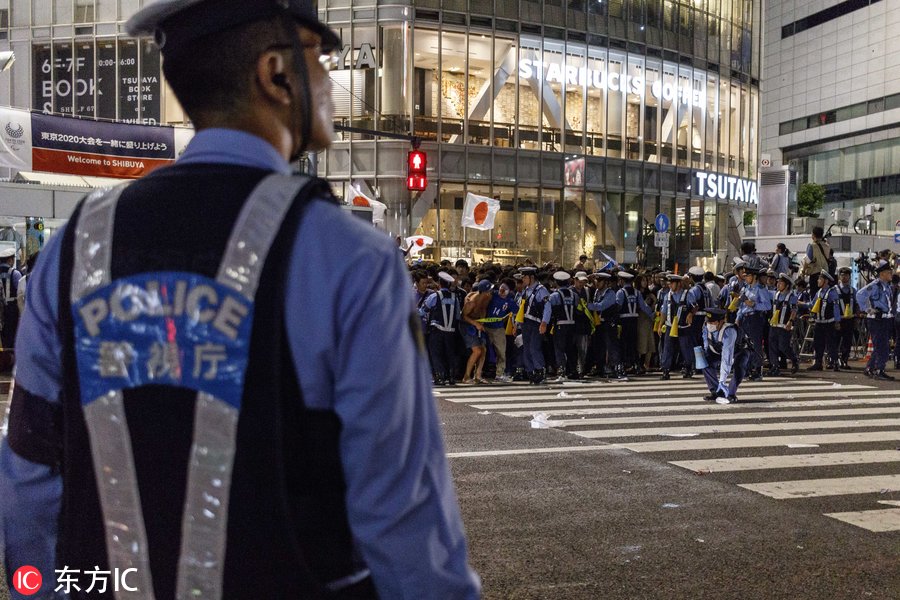 日本世界杯球迷(日本球迷街头狂欢庆祝第三次世界杯小组出线 大量警力维持秩序)