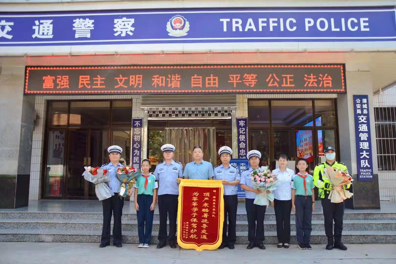 公安局交通管理大队送来锦旗,鲜花,感谢蒲城交警长期以来坚守"护学岗"