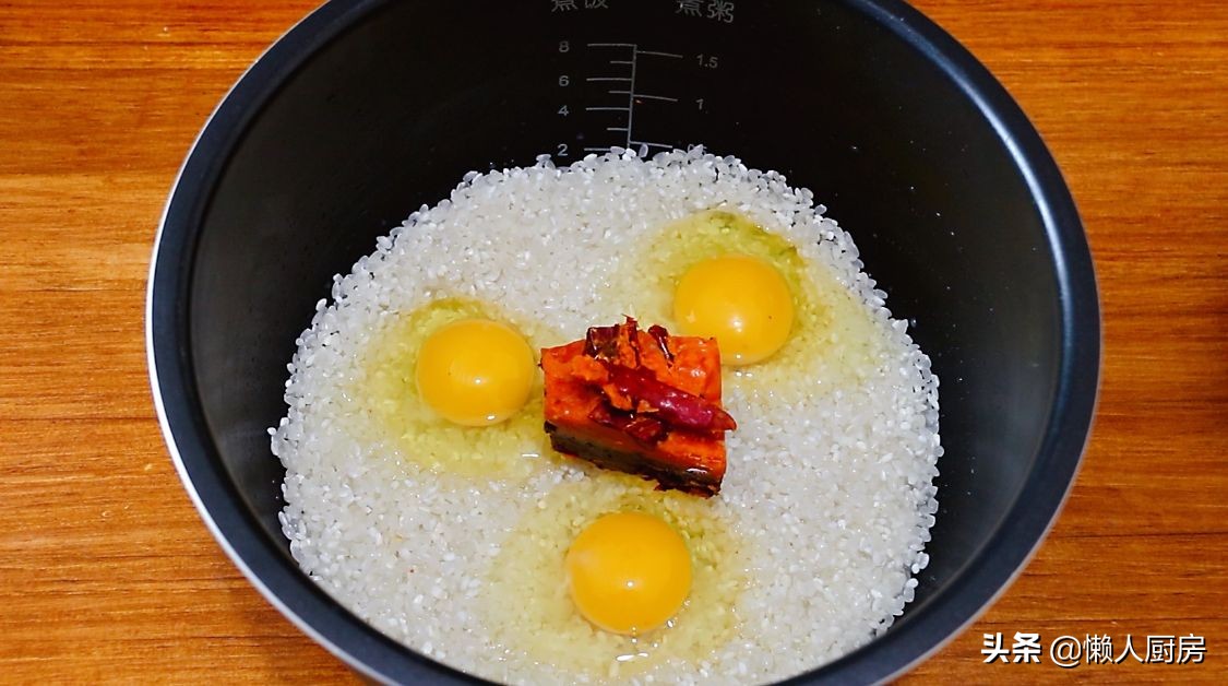 這是懶人燜飯的做法，大米里加一塊火鍋底料，打入3個雞蛋