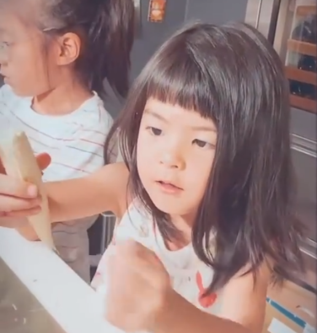 贾静雯两女儿在家洗菜，咘咘蝴蝶结造型养眼，哪知妹妹更抢镜