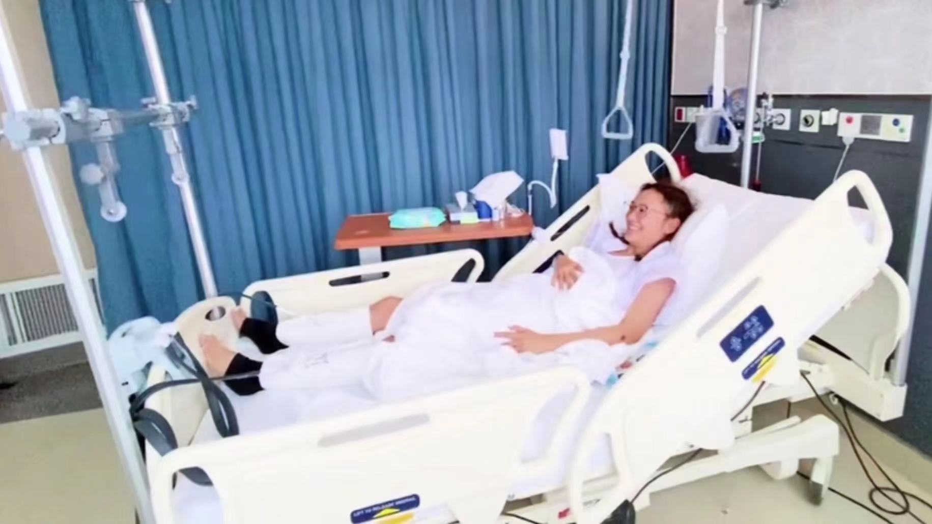38岁应采儿双腿打石膏，半卧病床进行康复训练，病房内追看奥运会