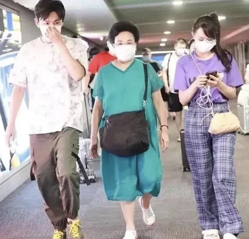 伊能静陪婆婆走机场，扎斜马尾配粉包真显嫩，比一旁秦昊看着还小