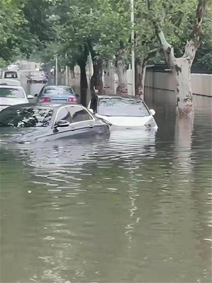 河南濮阳遭遇强降雨，濮阳小车被淹司机向车外舀水，遇特雨城雨最阳遇雨有游泳还有市民到街上游泳