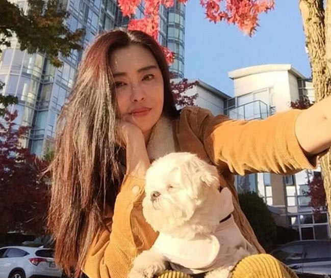 王祖贤罕见晒自拍，树下抱着宠物狗悠然自得，