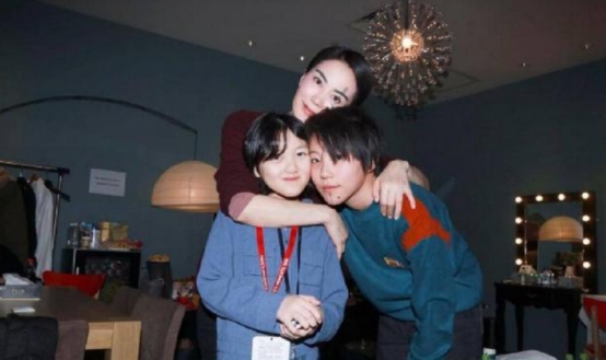 52岁王菲领女儿李嫣聚餐，身材精瘦锁骨突出，蹲路边玩手机没包袱