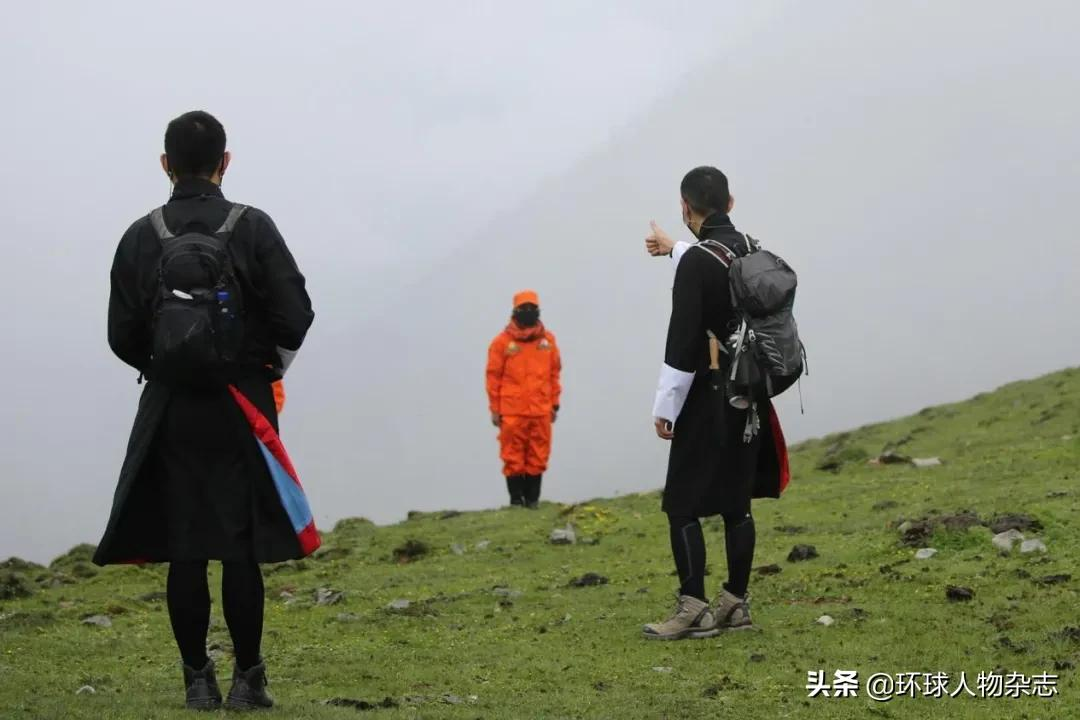 旺楚克(圖中戴黑色帽子者)和工作人員徒步行走在山間.